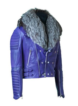 A woman wearing a blue leather biker jacket with a detachable fox fur collar and a zipper closure.