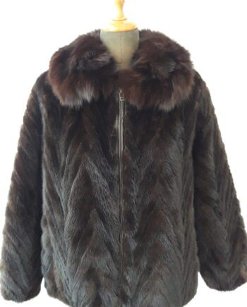 A white section mink jacket with a stand collar and a hook and eye closure