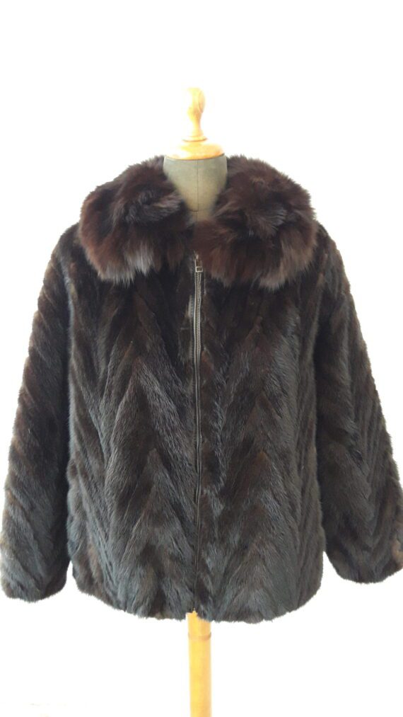 A white section mink jacket with a stand collar and a hook and eye closure