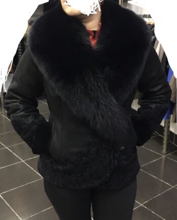 A woman wearing a black sheepskin coat with black fox fur trim and a black hat.