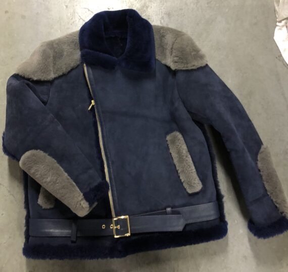 A navy blue napa racing shearling jacket with a front zip closure, two side pockets, one chest pocket, and a shearling collar, cuffs, and hem. The jacket has a slim fit and a sleek design