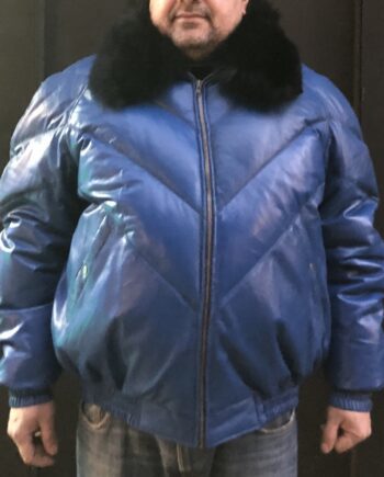 A man wearing a blue V-Bomber jacket with a fox fur collar and a black hat.