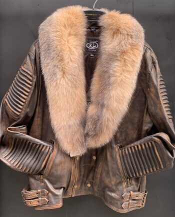 A man wearing a brown waxed biker jacket with fox fur collar, looking rugged and stylish.