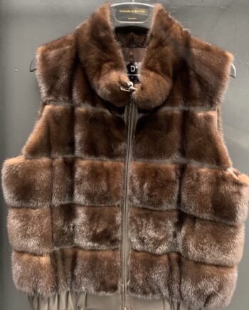 A woman wearing a brown mink fur vest with a zipper and pockets.