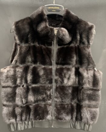 A woman wearing a brown mink fur vest with a zipper and pockets.