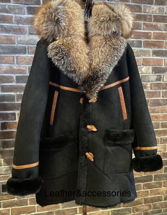 a 3/4 length coat made of shearling sheepskin and crystal fox fur, with a detachable hood, button closure, and side pockets. The coat is black and has a smooth and shiny surface.